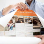 Person unrolling poster of printed Kudoboard