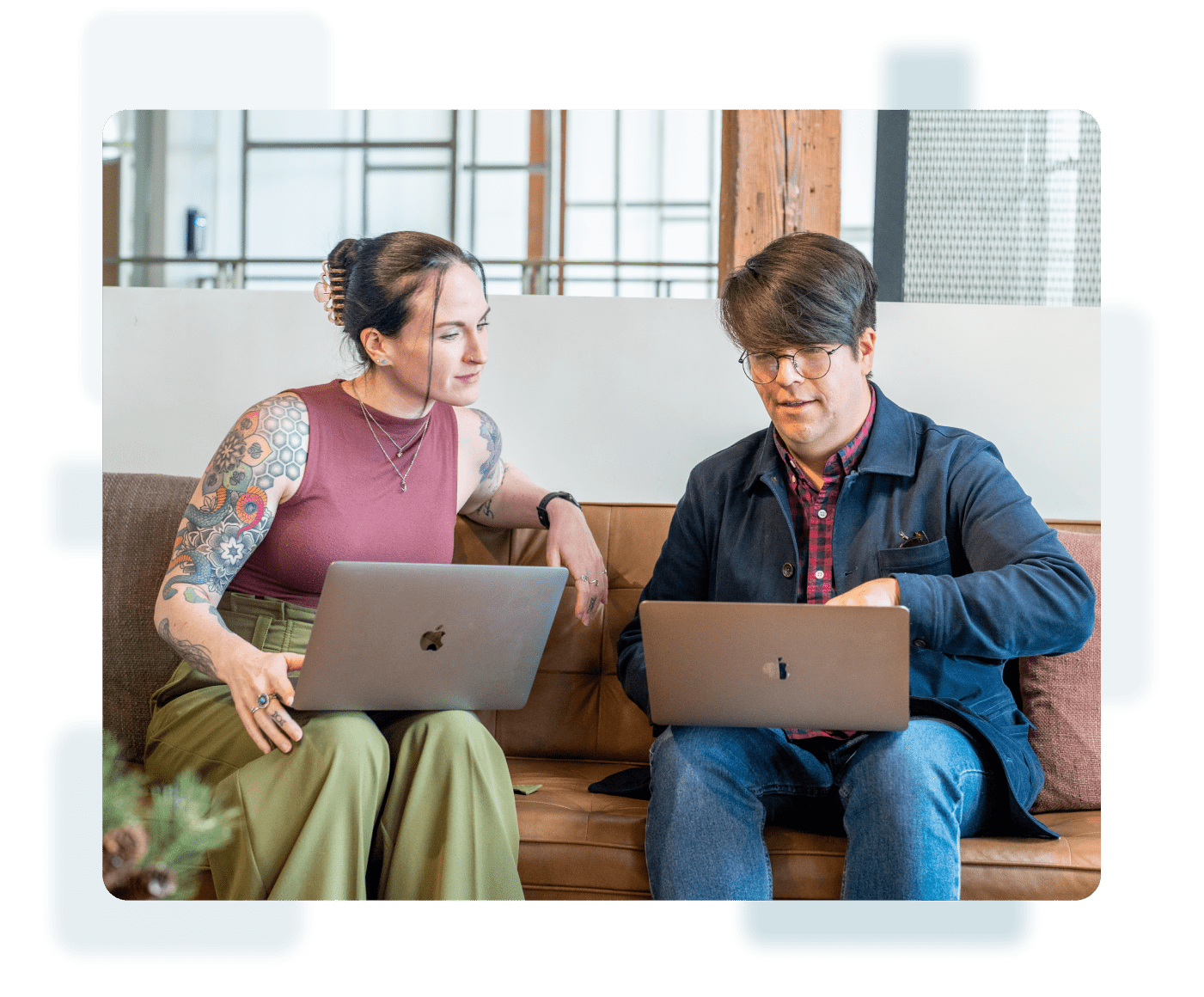 Two people sitting on a couch using laptops