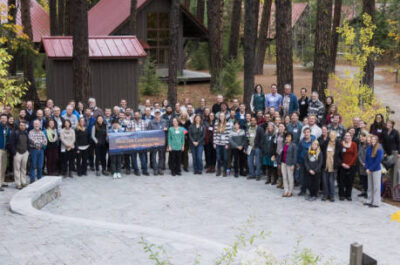 Group of employees holding banner together in the woods