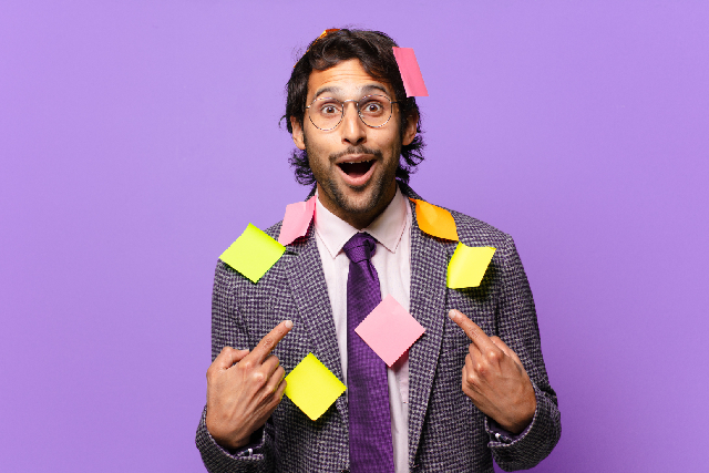 man covered in employee recognition notes pointing to himself